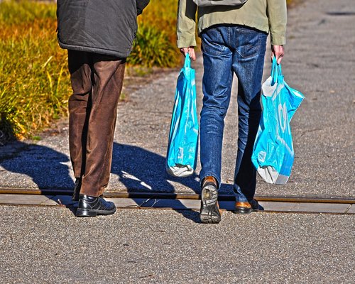 A person walking up stairs carrying groceries